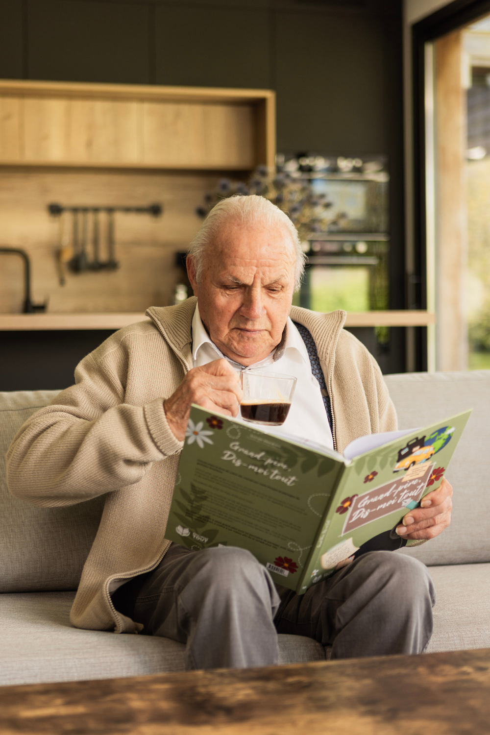 livre grand-père, dis-moi tout tenu en mains avec un café