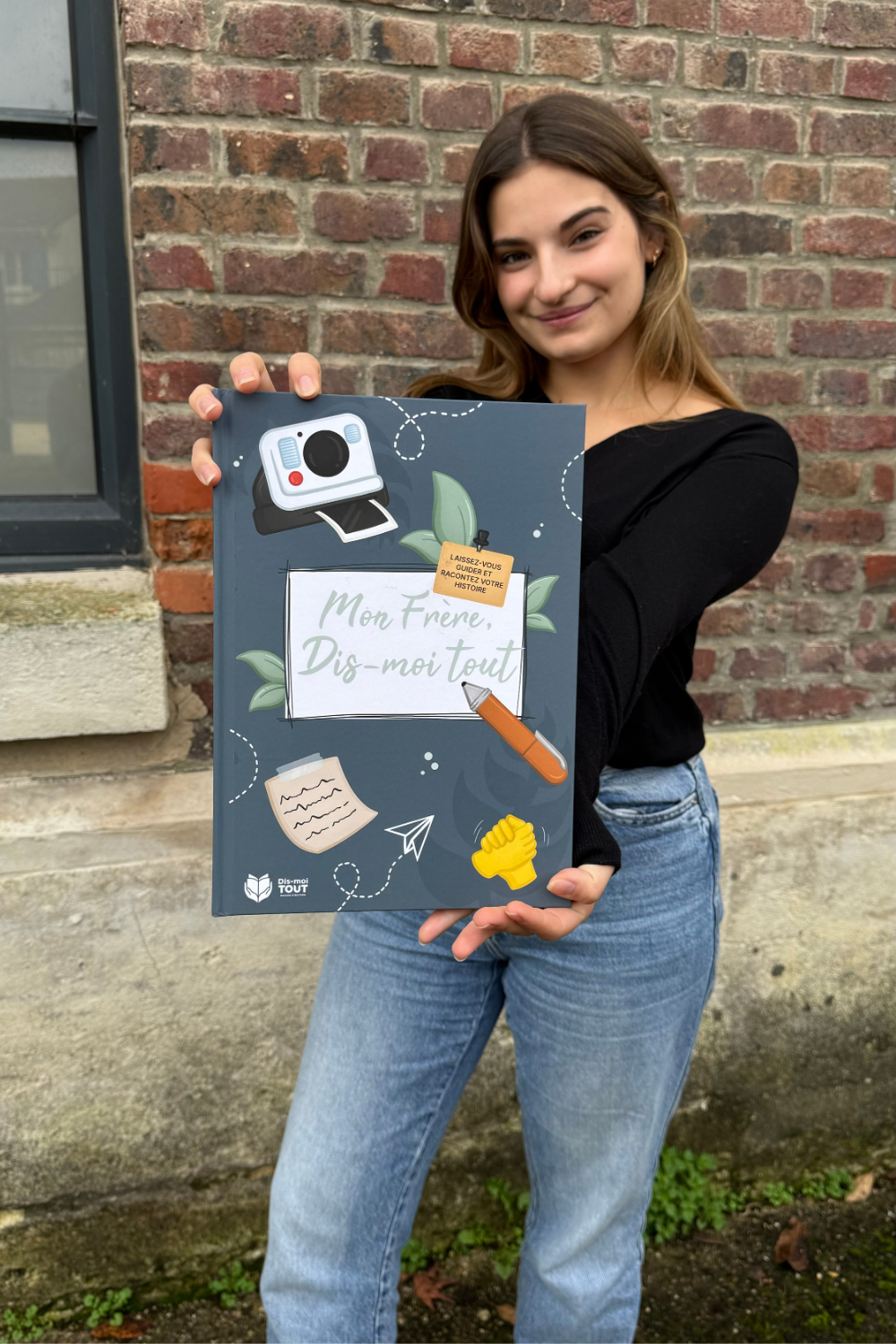 Une fille tient entre ses mains le livre "Mon frère, Dis-moi tout"