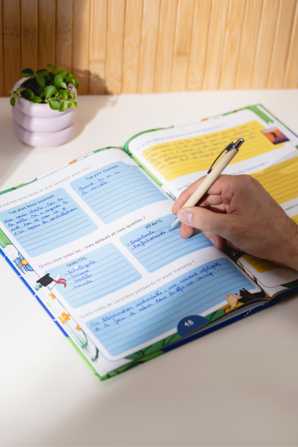 Photo du livre Dis-moi tout ouvert avec une main qui est entrain d'écrire dedans