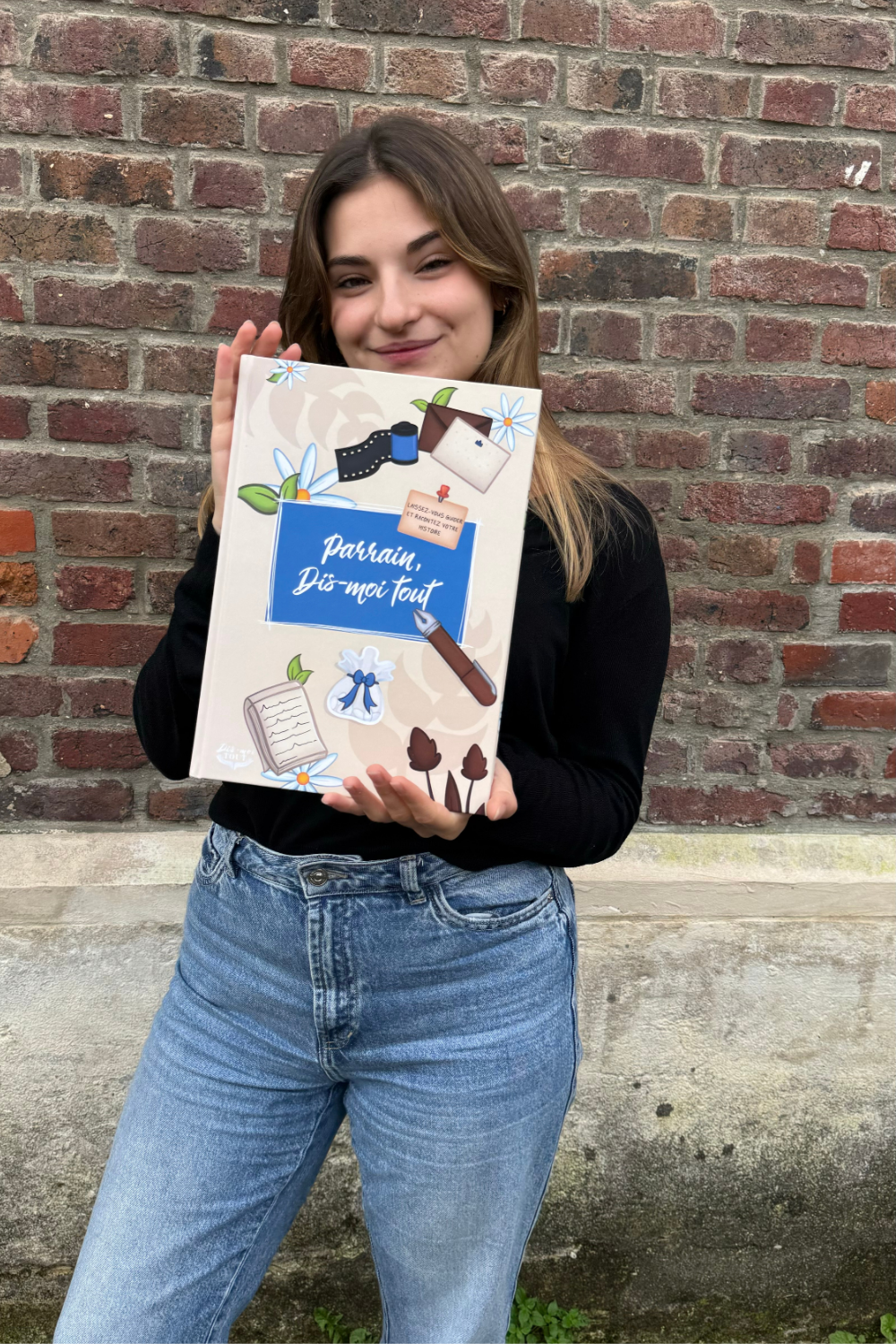 Une fille tient entre ses mains le livre "Parrain, Dis-moi tout"