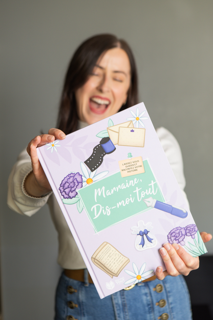 Une femme nous montre le livre "Marraine, Dis-moi tout"