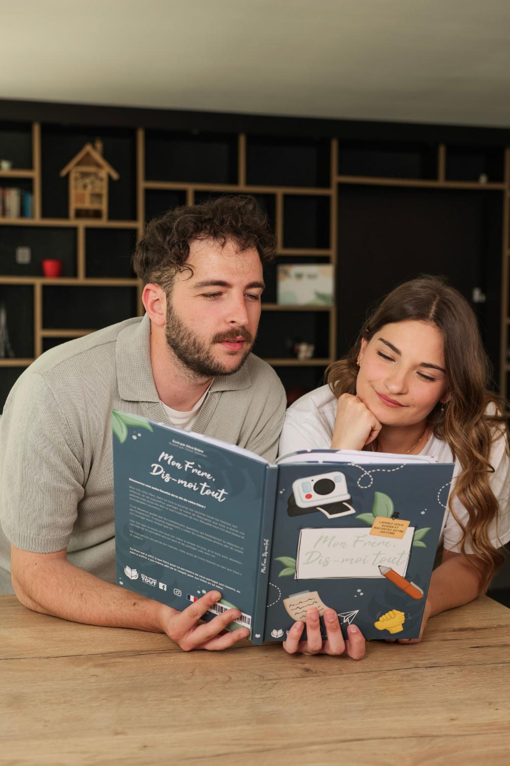 Un frère et sa soeur sont entrain de lire le livre "Mon frère, Dis-moi tout"