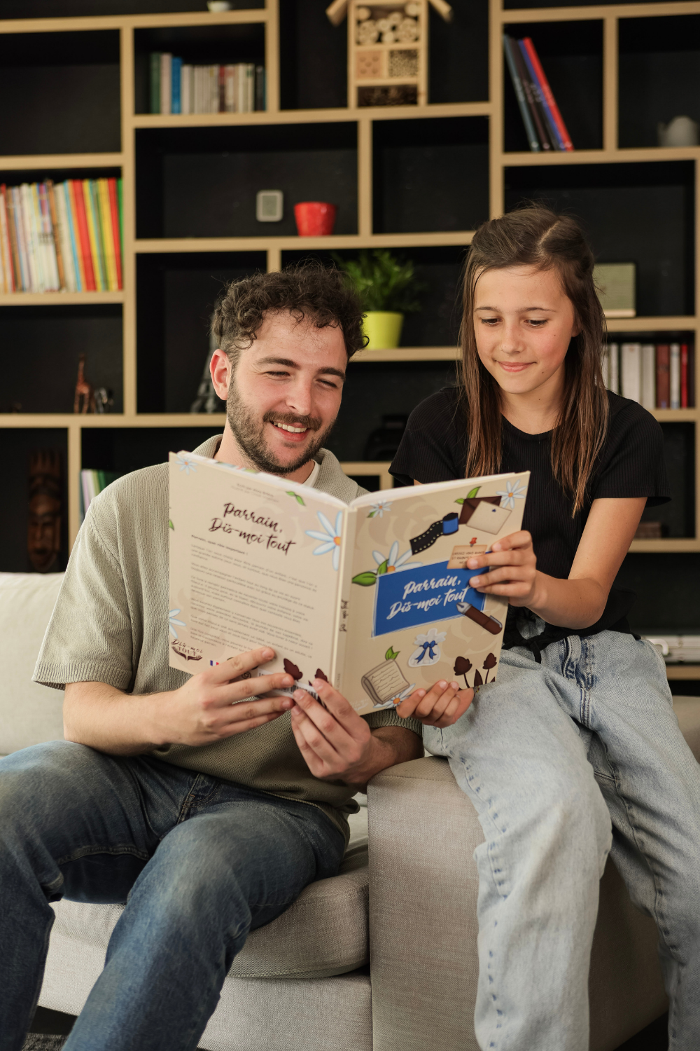 Un parrain et sa nièce sont entrain de lire le livre "Parrain, Dis-moi tout"